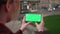 Young caucasian woman hands hold smart phone with horizontal green screen outdoors internet mobile smartphone technology