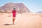Young caucasian woman hold map disoriented lost read map alone in desert in extreme heat. Wadi rum desert hike and hiking routes
