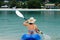 Young caucasian woman kayaking over turquoise water