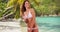 Young Caucasian woman modeling bikini beneath palm trees on Caribbean beach
