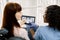Young caucasian woman patient sitting in dentistry chair and pointing on the tablet with teeth panoramic radiography