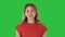 Young caucasian woman pointing with hand and finger to the side on a Green Screen, Chroma Key.