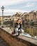 Young caucasian woman posing in front of amazing bridge Ponte Vecchio, Florence, Italy