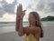 Young caucasian woman practice eagle yoga pose in seaside at sunrise