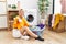 Young caucasian woman putting dirty laundry into washing machine smiling friendly offering handshake as greeting and welcoming