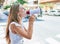 Young caucasian woman screaming using megaphone at the city