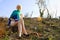 Young caucasian woman seated in barren landscape