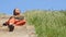 Young caucasian woman sitting on the wooden stair and enjoying life in sunshine weather