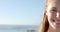 Young Caucasian woman smiles brightly at the beach, with copy space