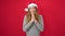 Young caucasian woman smiling praying wearing christmas hat over isolated red background