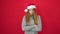 Young caucasian woman standing upset wearing christmas hat over isolated red background