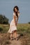 A young Caucasian woman strolling along a path in a picturesque steppe boundless landscape. Autumn or summer