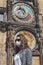 Young Caucasian woman with sunglasses and medical face mask photographed in front of the Astronomical clock Orloj in Prague, Czech