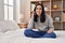 Young caucasian woman talking on smartphone sitting on bed at bedroom