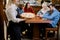 Young Caucasian woman waitress bringing pizza for group of diverse multiracial friends in cafe.