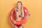 Young caucasian woman wearing bikini and holding lifeguard float looking at the camera blowing a kiss with hand on air being