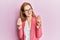 Young caucasian woman wearing business style and glasses doing money gesture with hands, asking for salary payment, millionaire