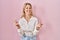 Young caucasian woman wearing casual white shirt over pink background showing middle finger doing fuck you bad expression,