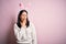 Young caucasian woman wearing cute easter rabbit ears over pink isolated background bored yawning tired covering mouth with hand
