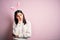 Young caucasian woman wearing cute easter rabbit ears over pink isolated background thinking looking tired and bored with