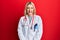 Young caucasian woman wearing doctor uniform and stethoscope sticking tongue out happy with funny expression