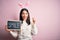 Young caucasian woman wearing easter rabbit ears and holding blackboard with smile word screaming proud and celebrating victory