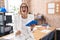 Young caucasian woman working at the office wearing glasses angry and mad screaming frustrated and furious, shouting with anger