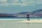 Young Caucassian woman enjoying holiday on a white sandy beach with turquoise water