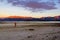 Young causacian man walking on beach at beautiful Lake Tekapo with mountain range in the Background on sunset with clouds, South
