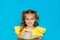 Young celebrating girl holding a piece of cake on blue background. Copy space