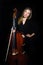 Young cellist standing on black background