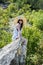 Young charm woman on a stone enjoying in landscape