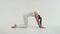 The young charming athletic sport woman doing the side bridge on the exercise mat at the white background.