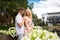 Young charming blonde girl is flirting and with a guy in the garden. Lovestory of a couple in love
