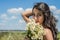 Young charming brunette girl with a bouquet of white field chamomiles on a summer sunny day