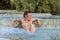 Young charming girl bathes in the healing thermal mineral springs in the resort of Saturnia Italy