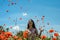 Young charming girl in a chamomile poppy field tosses petals of poppies on a bright sunny day