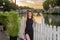 Young charming girl in a dress during a walk at sunset along the Tiber River embankment near the Vatican