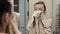 Young charming girl wipes her face with a towel in front of a bathroom mirror