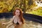Young charming redhead woman is relaxing in hot tub whirlpool jacuzzi outdoor