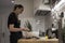 Young charming Swedish woman cooking at home in her kitchen, preparing healthy mediterranean food for her family. Young food