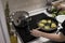 Young charming Swedish woman cooking at home in her kitchen, preparing healthy mediterranean food for her family. Young food