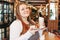 Young charming woman plus size with milkshake and croissant in hands in cafe, enjoing life and her appearance