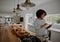 Young cheerful african american woman checking recipe on digital tablet while preparing vegetable salad in kitchen