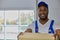 Young cheerful contractor man helps to make home move, carries boxes with things