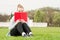 Young cheerful female hiding her face with book