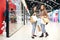 Young cheerful females in jeans and jackets standing by display in trade center