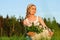 Young cheerful girl with blond hair with a basket of lilacs. Summer moment. blonde girl in a white dress and a nice hat holds a