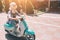 Young cheerful girl driving scooter in in city. Portrait of a young and stylish woman with a moped