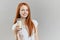 Young cheerful girl holds a glass of milk